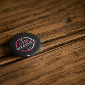 Sleek Black Pin Button on Rustic Wooden Surface